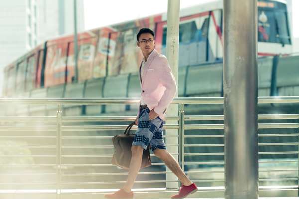 Glasses by Oliver Peoples, jacket and pochette by Richard James, shirt by Boglioli, shorts by Engineered Garments, belt by Hackett, shoes by Oliver Spencer, bag by Bottega Veneta