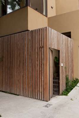 Street view of the house, protected by wooden fencing 