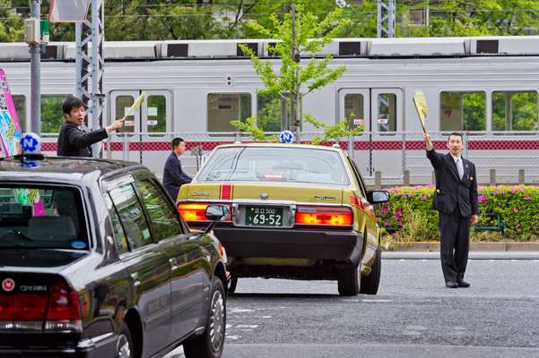 Directing traffic as taxicabs leave the depot in the morning