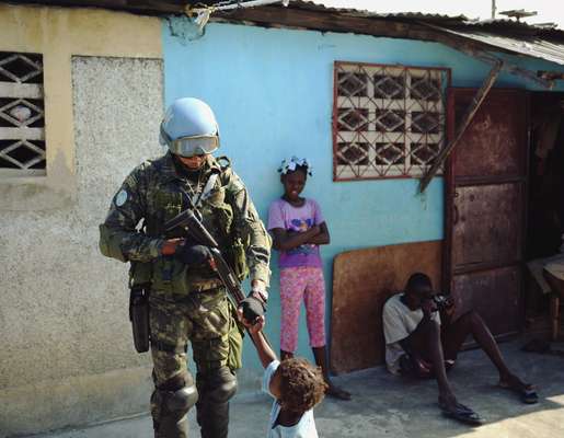 Brazilian soldiers bump fists with children in Cité Soleil