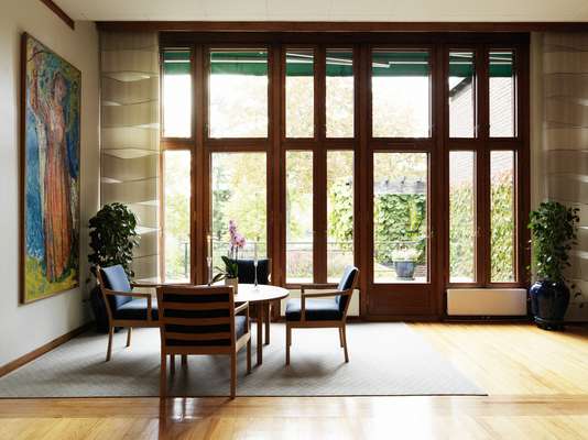 Teak-framed windows open out into the embassy garden