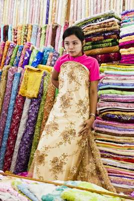 Vendor modelling fabric for wedding dress in stall at Scott Market