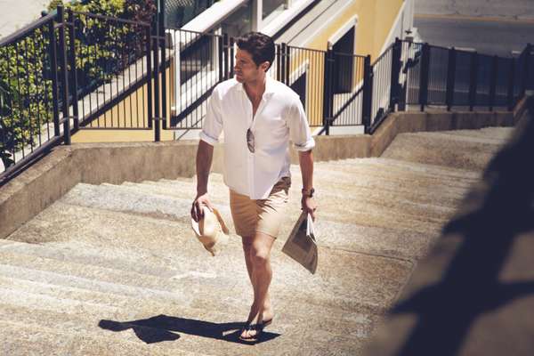 Polo shirt by Brioni, sunglasses by Lindberg, shorts by Blue Work from Tomorrowland, sandals by Canali, hat by Mühlebauer, watch by Bell & Ross