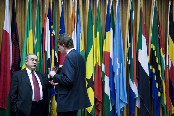 Visitors stand in front of the flags of member states in the AU headquarters