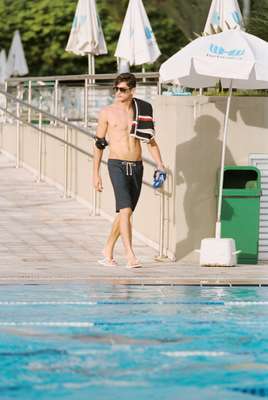 Swimming trunks by Dunhill, sunglasses by Thierry Lasry, chain by Gucci, towel by Moncler, goggles by Speedo, swim cap by Arena, watch by Seiko, pouch by Porter, flip-flops by Monocle x Havaianas