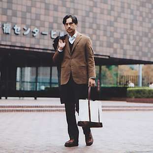 Jacket by Akamine Royal Line, trousers by Prada, jumper by United Arrows, shirt by Ermenegildo Zegna, shoes by Russell Moccasin for Nepenthes, coat by Hermès, bag by Porter