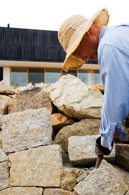 Owner Shigemi Asano building a stone wall