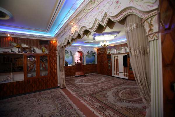 Persian carpets meet blue fluorescent lighting in Hamkar’s sitting room