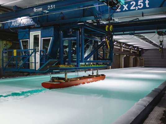 A scale model icebreaking cargo ship is tested in the Aker Arctic facility