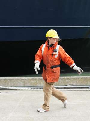 Shore crew run to catch lines thrown from the arriving ferry