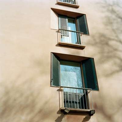 Recessed windows with angled shutters and short balcony on Casa Pirelli