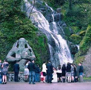 Wedding party in front of a statue dedicated to St Andrew