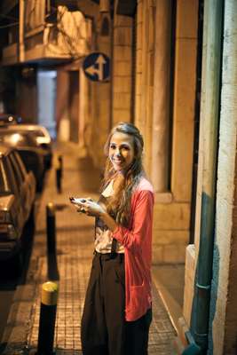 Fashion assistant Tala Hjiar sends a text outside Kayan bar, Rue de Liban