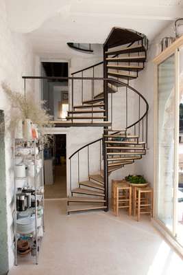Modern circular stairs lead up to the top floor