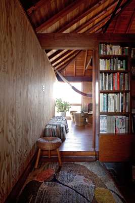 Second floor: Second floor, at the top of the stairs is a 1950s rug and rattan school. A bookshelf doubles as a partition. 