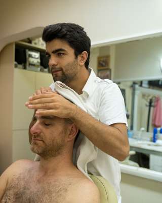 Simsek providing the traditional post-haircut head-and-shoulder rub