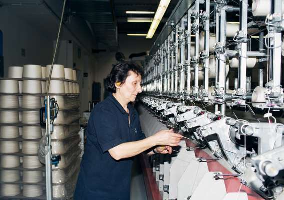 Employee twisting the threads during the spinning process