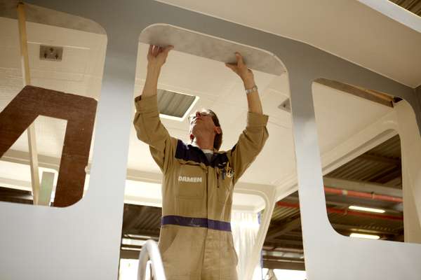 A carpenter works on a bridge cabin