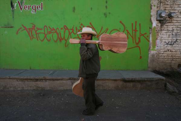 A guitar player takes his instrument for finishing