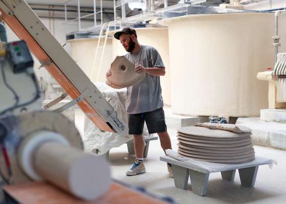 A 'cake' of porcelain mass is put through a machine that removes air