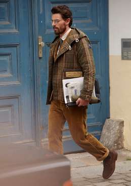 Coat by R.Newbold, jacket and trousers by Comme des Garçons Homme, shirt by Paul Smith, tie and shoes by Brunello Cucinelli, glasses by Mykita, laptop case by The North Face, umbrella by Knirps