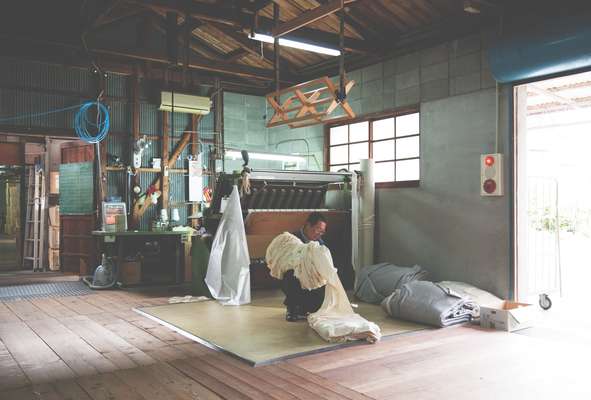 A worker manually turns the cloth right-side out