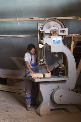 A carpenter uses an industrial saw at Roda yard