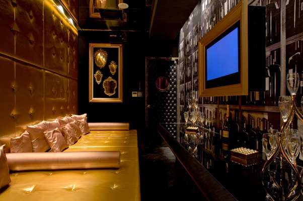 The six-person Room A is dominated by a huge gold vinyl daybed and padded walls with a private champagne bar and karaoke plasma screen along one side 