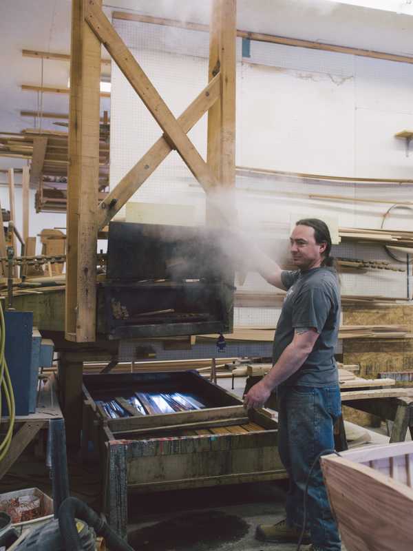 Employee pulling steamed wood