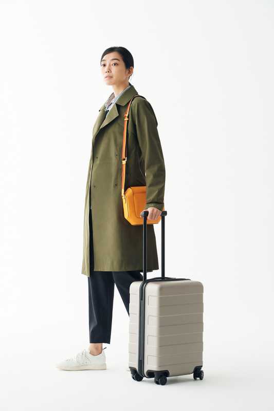 Coat by Arc’teryx, shirt by Gant, trousers by Barena, trainers by Golden Goose Deluxe Brand, bag by Hermès, suitcase by Muji