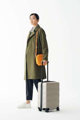 Coat by Arc’teryx, shirt by Gant, trousers by Barena, trainers by Golden Goose Deluxe Brand, bag by Hermès, suitcase by Muji