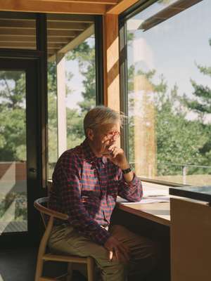 Canadian architect Ian MacDonald in his cabin home on the shore