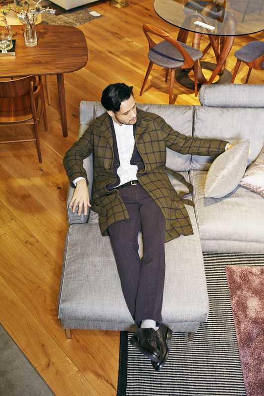 Coat by Stile Latino from Beams, jacket and trousers by Circolo 1901, shirt by United Arrows, socks by Tabio, shoes by Crockett & Jones, belt by APC, sofa by Eilersen