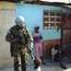 Brazilian soldiers bump fists with children in Cité Soleil
