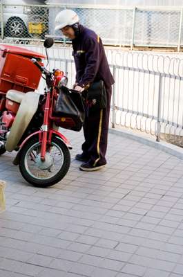 Postman with a Honda Super Cub. It’s efficient on fuel, using 1 litre per 100km