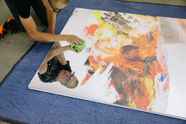 Worker readying a piece from the Korakrit Arunanondchai exhbition