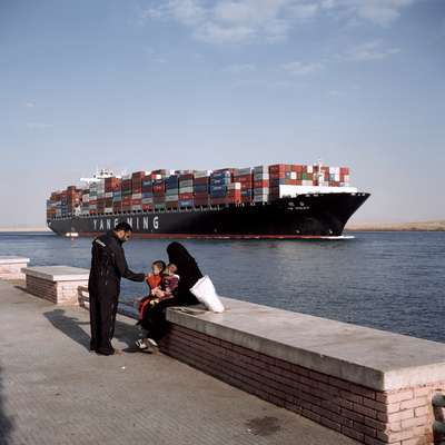 Container vessel passing through town of Suez