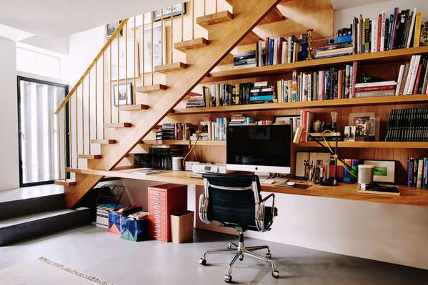 Stairs extend to become shelves. The brass handrail was custom-made for the project
