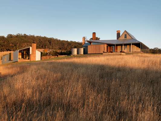 The Cottage and Shearing Quarters share the open grassland of a broad promontory overlooking Storm Bay 