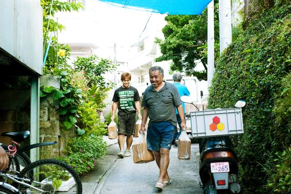 Craftsmen from Tsuboya pottery atelier, called Ikutouen, transporting materials to their atelier