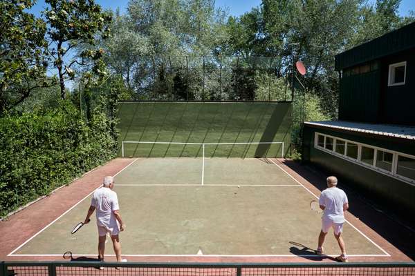 Members squeezing in a few sets at the practice tennis court 
