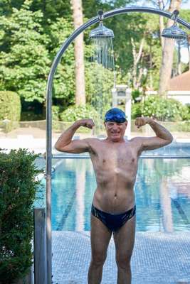 Member showering (and flexing) before a swim 