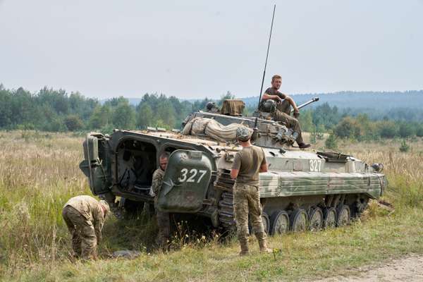 Ukrainian troops refill their vehicle while on a training mission