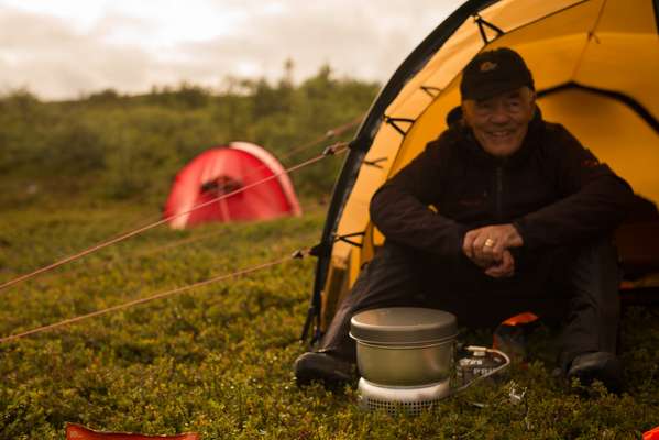 Hilleberg, sitting in  one of his tents with  a Trangia stove