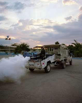 An anti-malaria fumigation team sprays General Barcellar Camp 