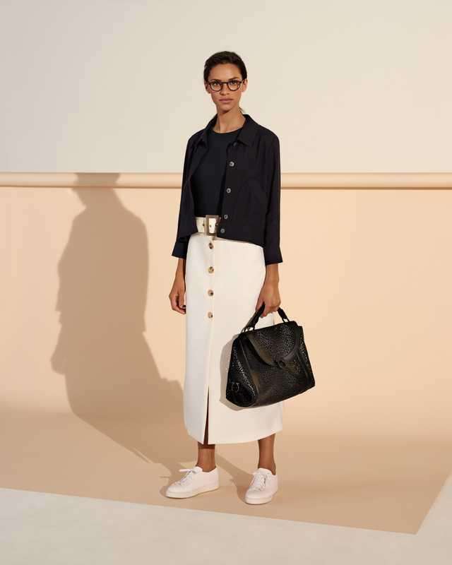 Jacket by Maison Kitsuné, pullover by Norse Projects,  skirt by Bella Freud, trainers by Santoni, glasses by Lindberg,  bag by Salvatore Ferragamo