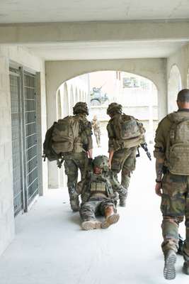 An injured soldier being dragged to safety in a training battle