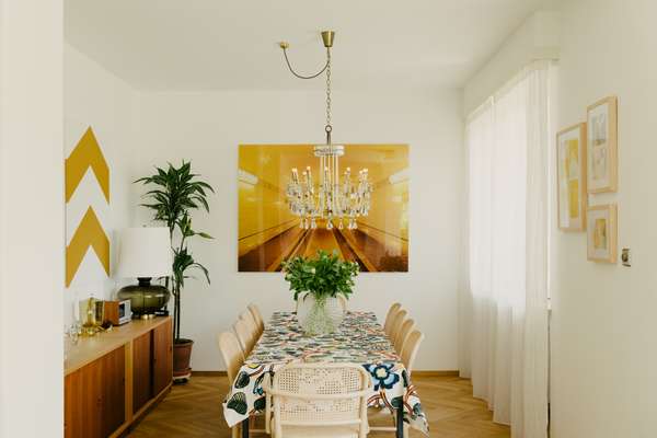 Dining table with Marimekko tablecloth, Svenskt Tenn vase and Thonet chairs; vintage chandelier by Austria’s Lobmeyr; photograph of Hamburg’s Elbtunnel by David Willen