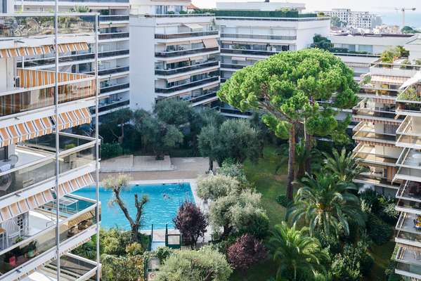 Greenery surrounds the turquoise swimming pool