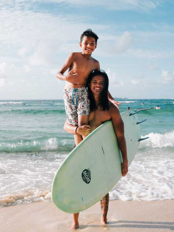 Surf instructor showing  a young pupil how to stay  on top of the waves 